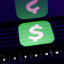 A phone screen displays a digital payment app logo and reflects back glowing blue lines of binary code.