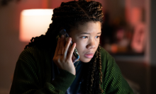 A teenage girl speaks on the phone.